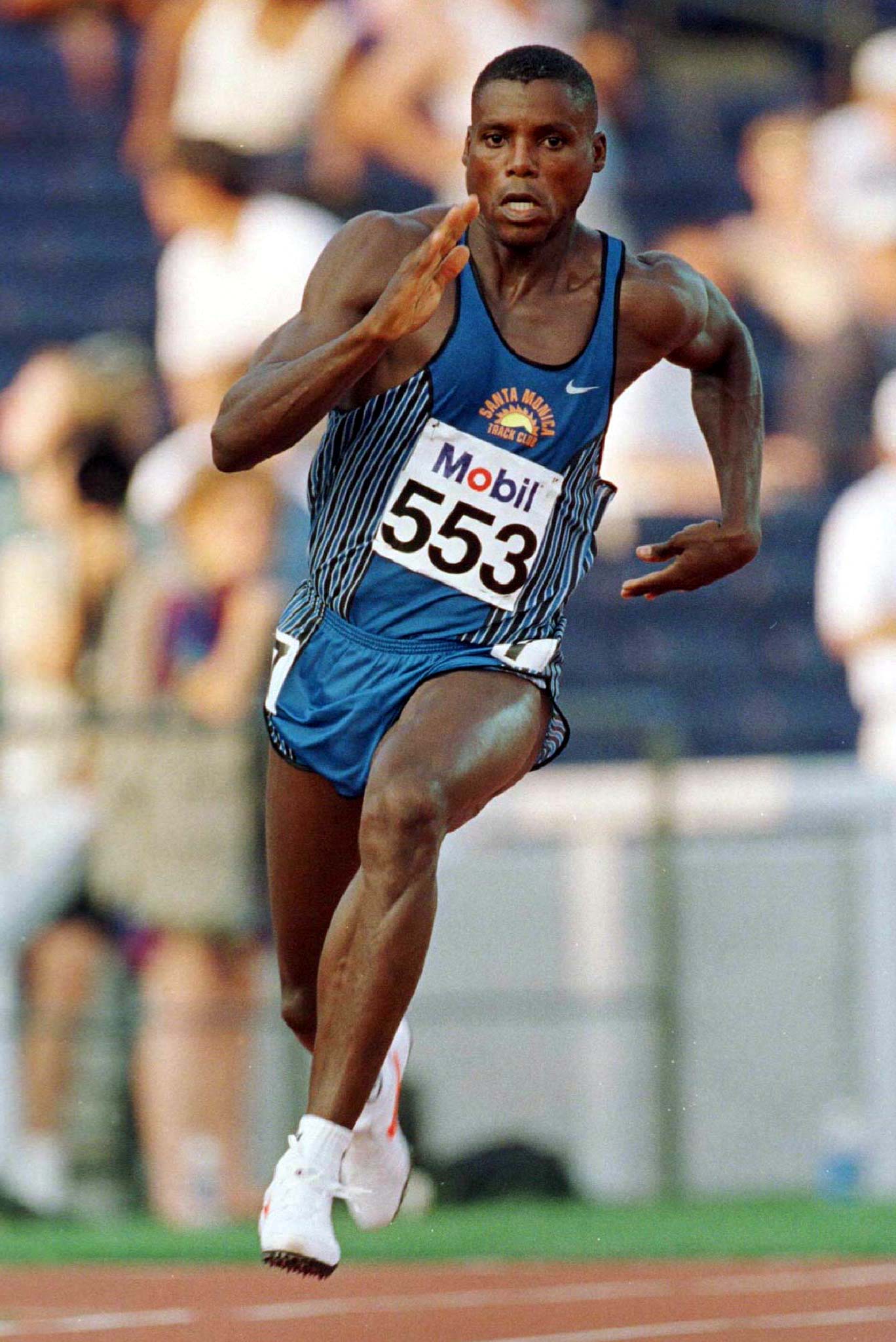 Carl Lewis races through a turn during his heat in the first round of