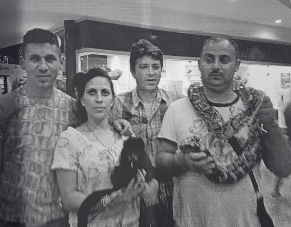 Filip Sărdaru (first person on the right), the head of one of the trafficking cland, had his picture taken in Mexico, with a snake around his neck